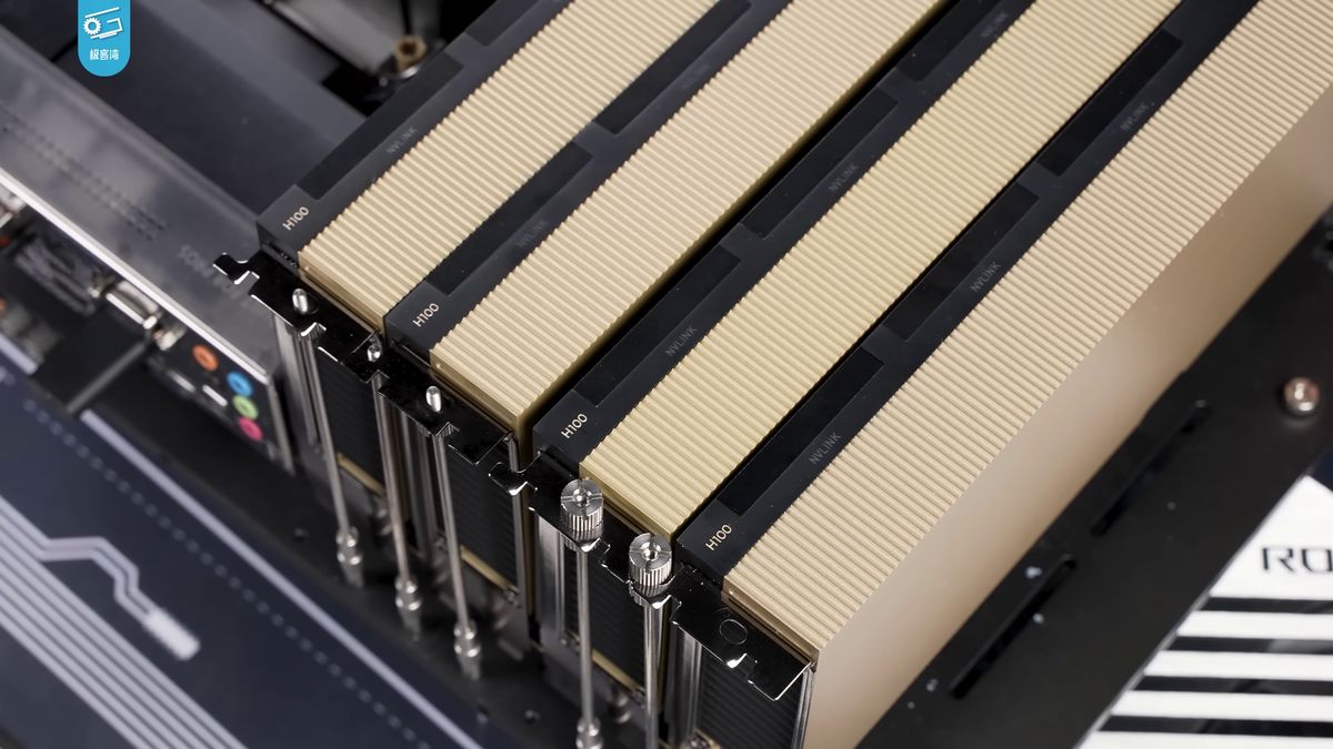 Four gold-and-black NVIDIA H100 GPUs installed side by side in a computer.